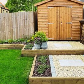 Giardino ristrutturato con capanno e muro di contenimento con gradini